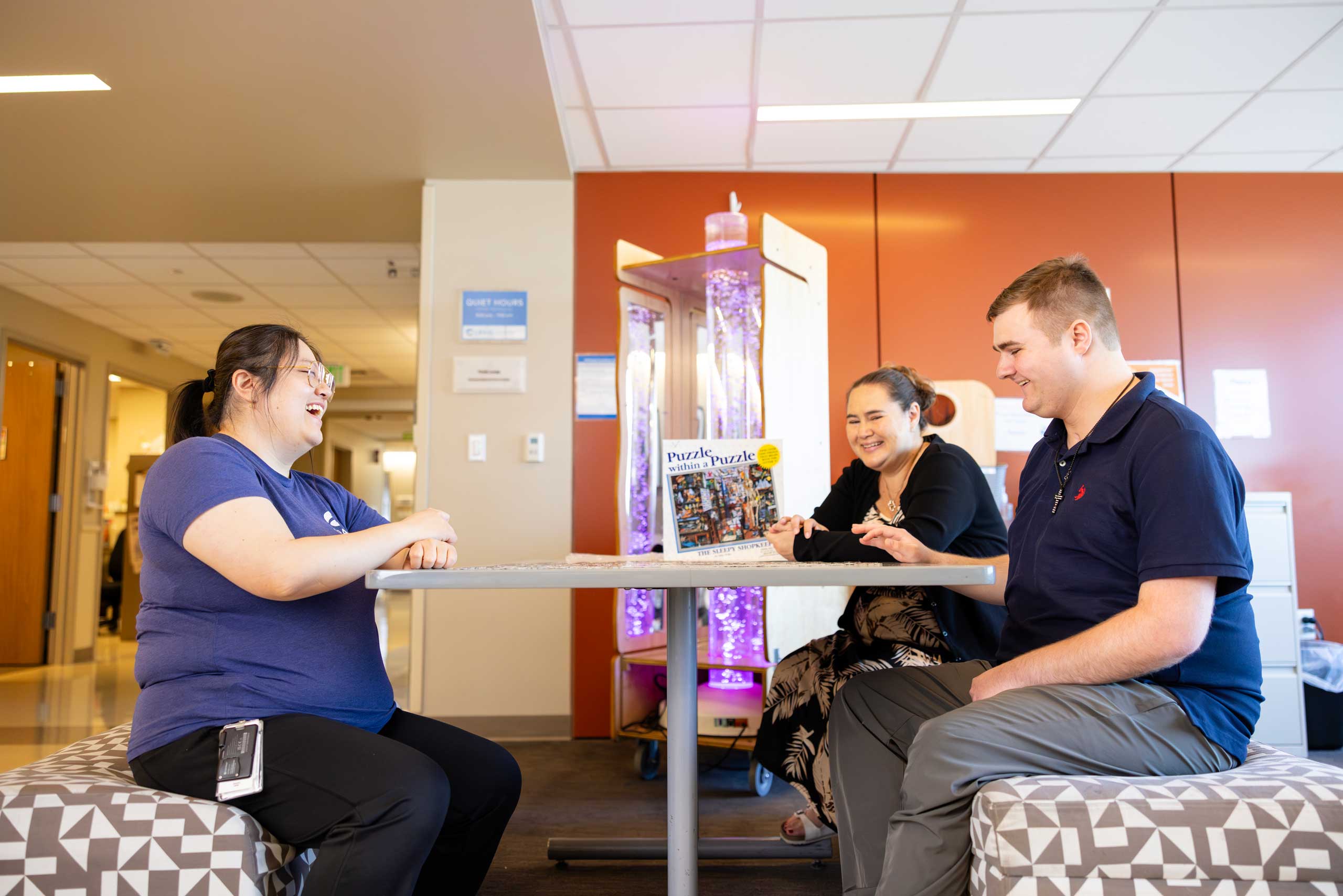 patient and staff members doing a puzzle at a table