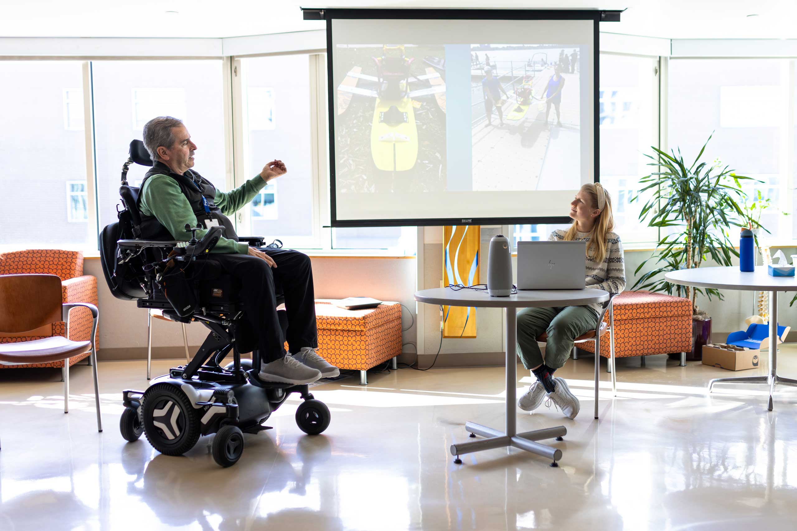 Patient in a wheelchair showing slides to the staff member