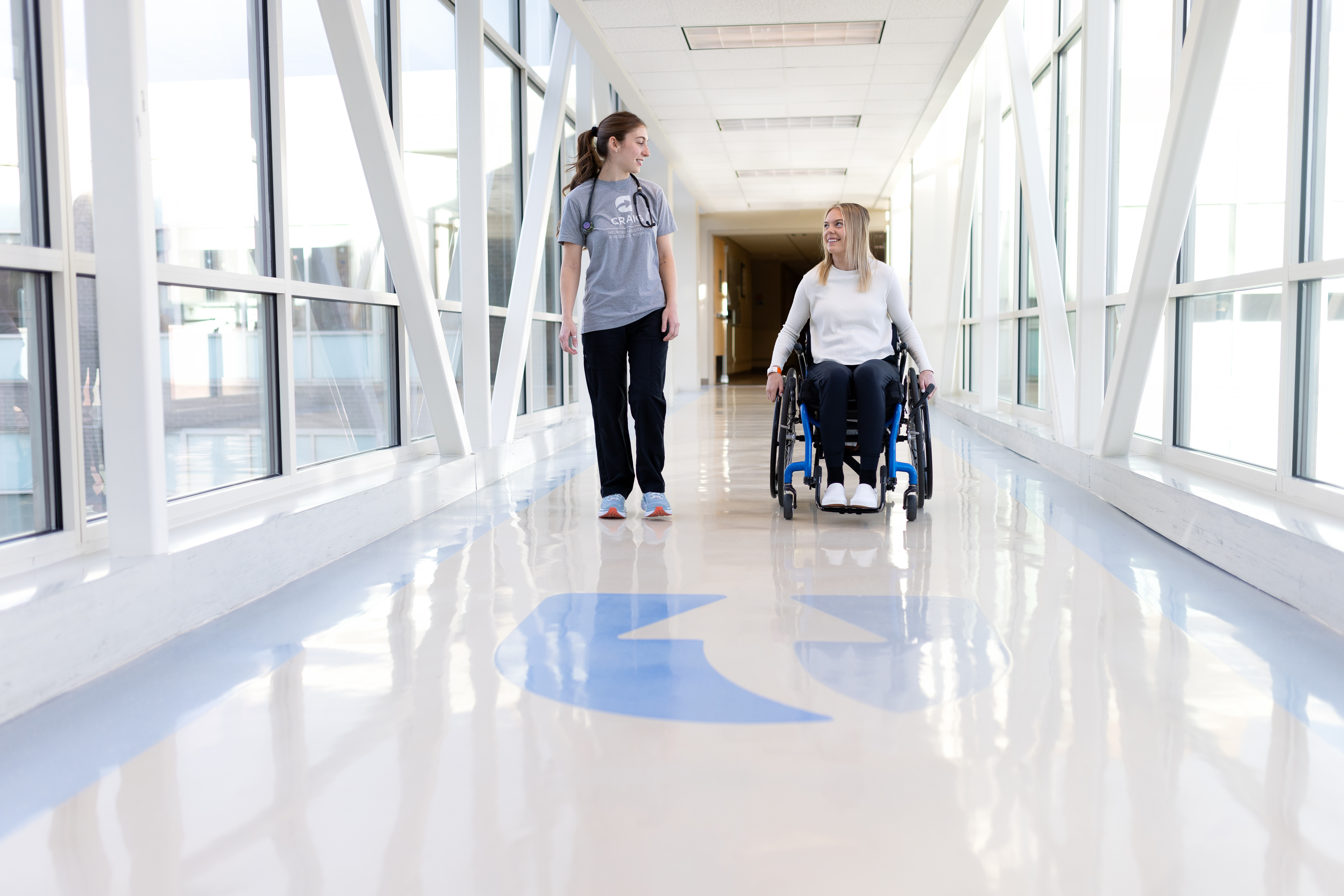 patient in a wheel chair and a hospital staff 