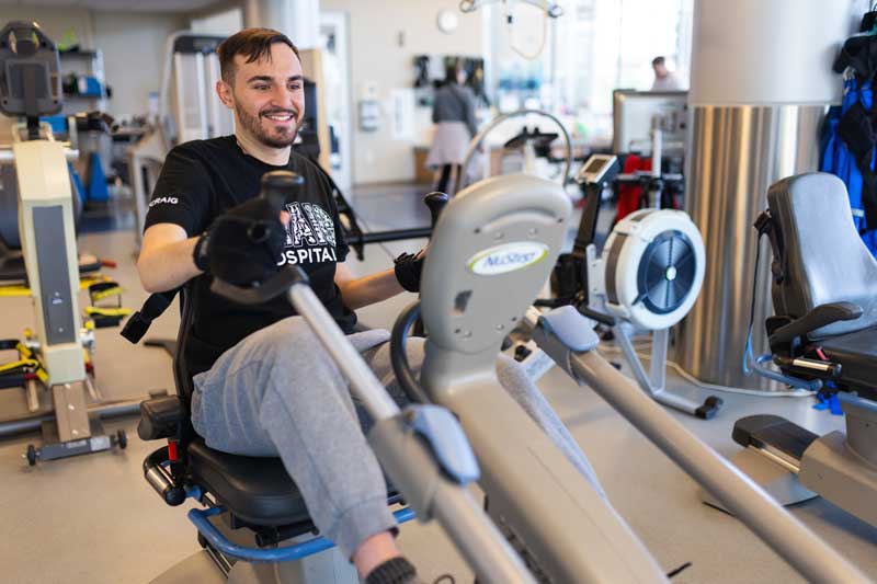 patient excercising on a machine in a rehab gym